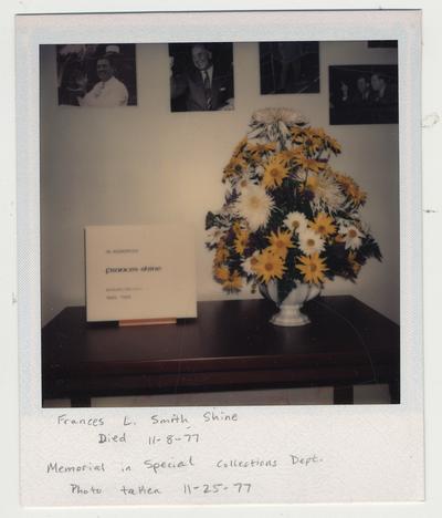 A flower arrangement sits beside a memorial in Special Collections that reads 