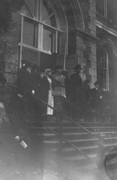Group of people in front of the Administration Building; man on far left, top of stairs (with white beard) is James K. Patterson (UK President, 1878-1910)