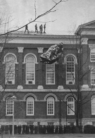 Administration Building, workmen on roof clearing away wind-damaged sections; Public Relation photo