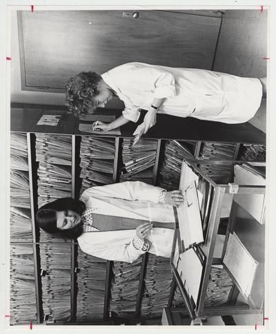 Two women going through files