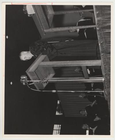 Previous president Herman L. Donovan is standing and speaking at the inauguration of president Frank G. Dickey.  Seated second from the left on the platform is Robert Marton, Eastern Kentucky University president