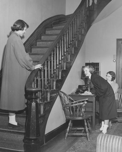 Three unidentified women in the lobby of a dormitory