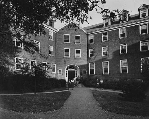 Seven unidentified women walking out of Boyd Hall, a woman's dormitory. Boyd Hall was built in 1925 and was named after Cleona Boyd