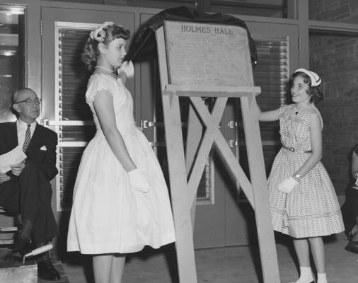 Sarah Bennett Holmes' granddaughters reveal the plaque for Holmes Hall at the dedication on May 25, 1958. Received May 25, 1958 from Public Relations