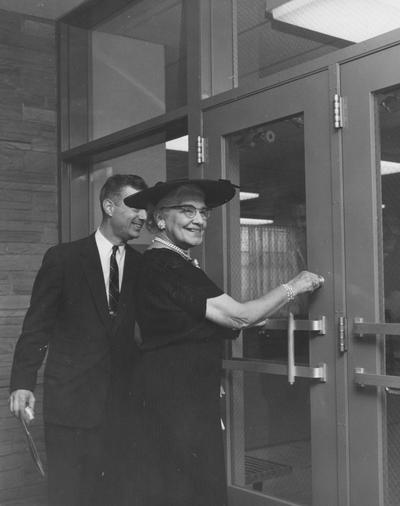 President Dickey and Sarah Holmes are unlocking the doors to Holmes Hall at the dedication. Received May 25, 1958 from Public Relations