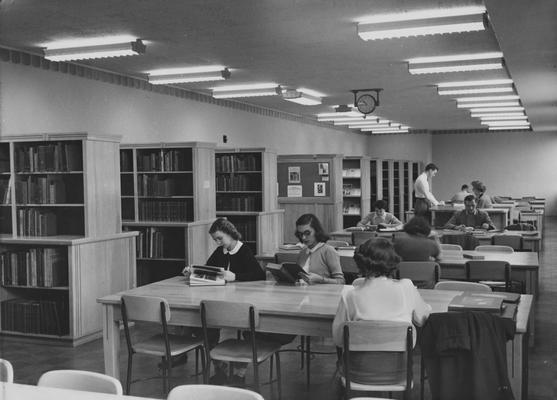 Students studying in the Fine Arts Library in the Fine Arts Building. (library was later relocated) Miss Algie Dickson is seated at the desk.  Photographer: John B. Kuiper