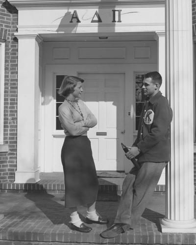 An unidentified woman in talking to an unidentified man in front of the Alpha Delta Pi House