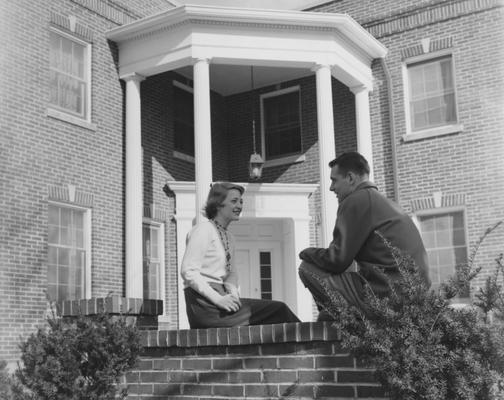 An unidentified woman in talking to an unidentified man in front of the Alpha Delta Pi House