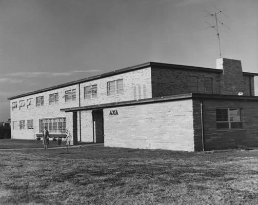 An unidentified woman is standing in front of the Lambda Chi Alpha house