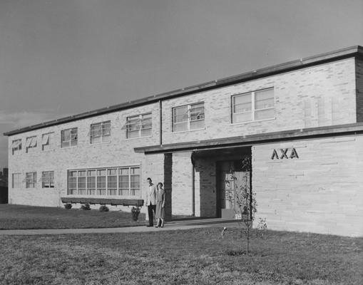 An unidentified woman and an unidentified man are standing in front of the Lambda Chi Alpha house