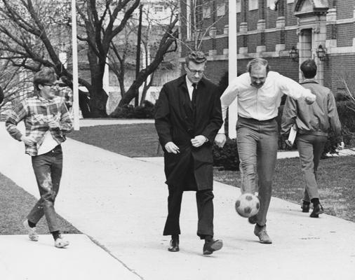 Three unidentified men kicking a ball on the sidewalk in front of the M. I. King Library. This photo appears second on page 195 of the 1969 