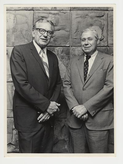 President Singletary (left) is standing with Richard Cooper (right) at a Board of Trustees meeting