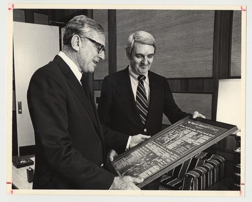 President Singletary receiving a framed article / plaque about the University of Kentucky's 1976 Peach Bowl victory over North Carolina from The Courier Journal and Times Vice President for public affairs, Donald B. Towles