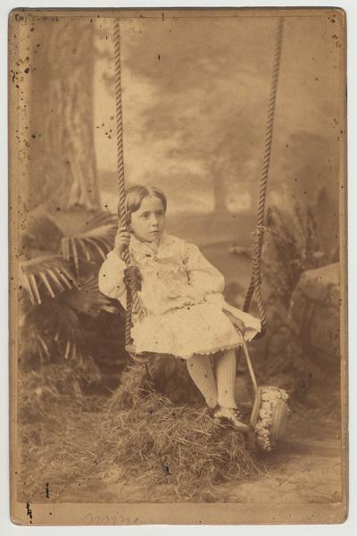 An unidentified girl is seated on a swing.  She is probably related to James White
