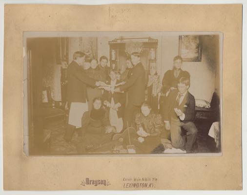 A group of unidentified people at a party and candy pulling at the house of James G. White, on the corner of Maxwell Street and Harrison Avenue