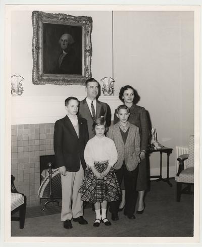 A Dickey family photograph taken in front of a fireplace.  Front row from the left:  Frank Dickey Jr., Ann, and Joe.  Back row from the left:  President Dickey and his wife Betty.  Received by Public Relations on August 17, 1957