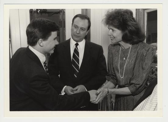 An unidentified student (left) speaks with President Charles Wethington and his wife, Judy.  They are at the Apple Polishing Party during Greek Week