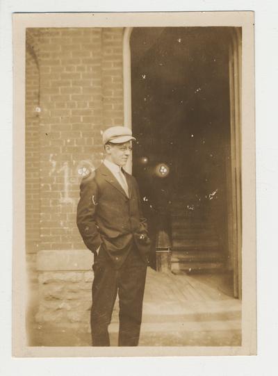 An unidentified man is standing in front of a building