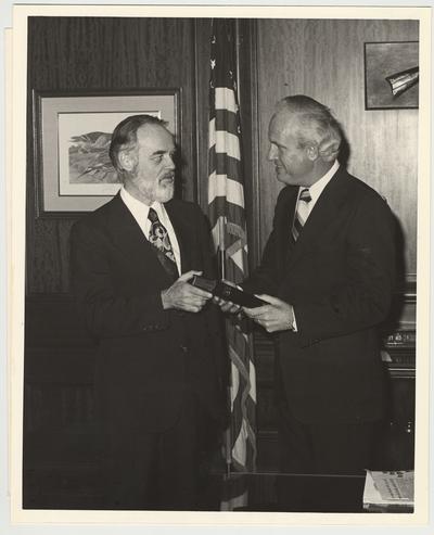 Julian M. Carroll, Governor of the state of Kentucky, (right) is being given a copy of the 