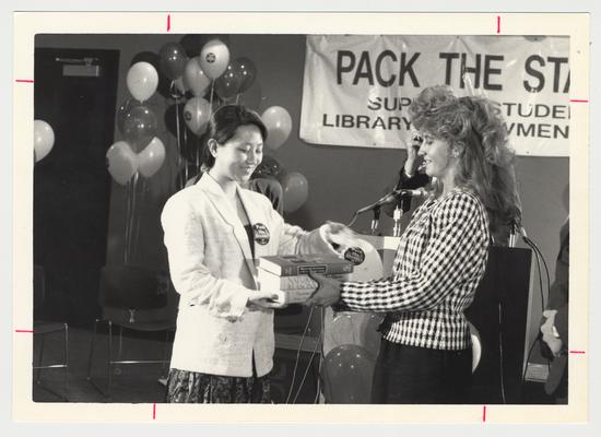 Chai Ling (left) symbolically accepts the first textbooks donated to the library from Diana Goetz (right) who graduated from UK in the spring of 1991 with a degree in Business