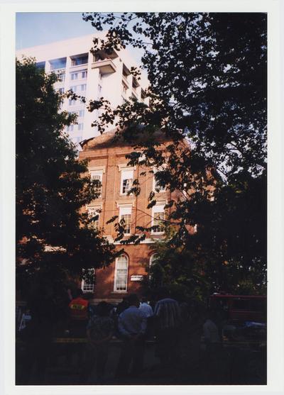 Unidentified people are standing outside of the Administration / Main Building during the fire.  Smoke can be seen coming from the roof