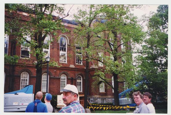 Unidentified men are standing outside of the Administration / Main Building during the fire