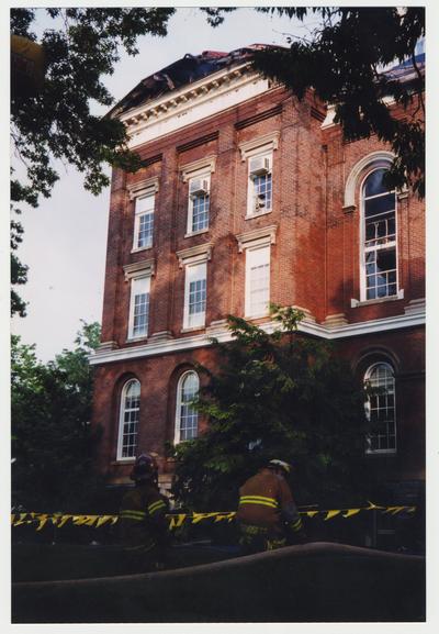 Two unidentified fire fighters are helping to extinguish the fire in the Administration / Main Building