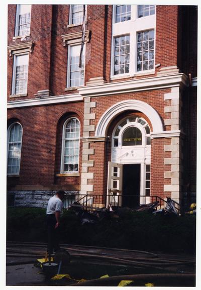 An unidentified men is standing outside of the Administration / Main Building during the fire