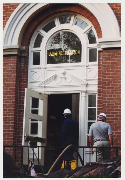 Unidentified men are walking into the Administration / Main Building after the fire was extinguished