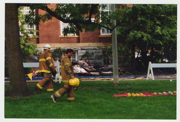 Two unidentified fire fighters are walking outside of the Administration / Main building after putting out the fire