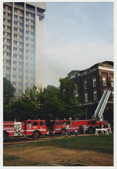 Two fire trucks are outside of the Administration / Main Building during the fire