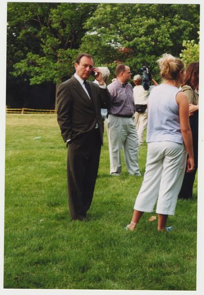 President Wethington is standing outside the Administration / Main Building during the fire with other unidentified people.  He is talking on a cell phone