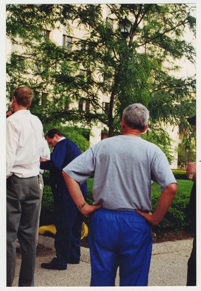 President Wethington (second from left) and other unidentified men are standing outside near the Administration / Main Building after the fire