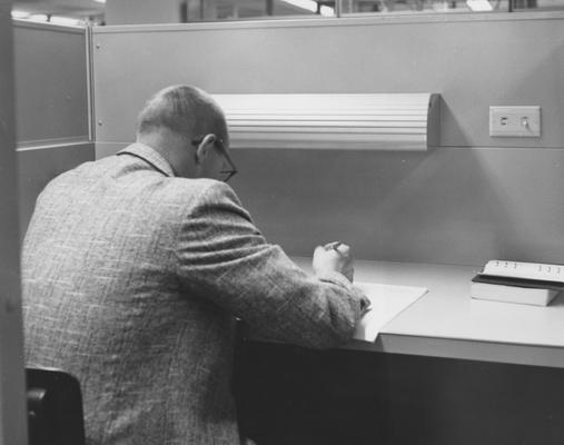 A man studying in the open stacks area in the M. I. King Library