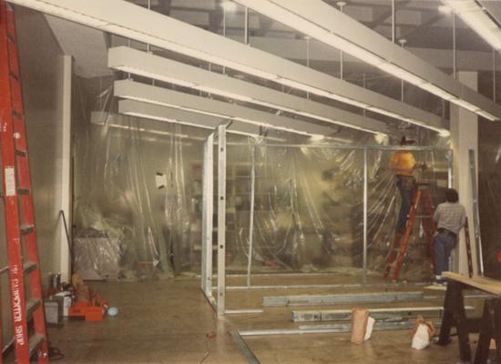 A color photo of the renovation of room 110, the Special Collections Department. Unidentified men are building new offices. Photographer: Terry Warth