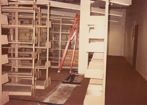 A color photo of an unidentified person building shelves for periodicals and serials on the second floor of Margaret I. King North Library. Photographer: Terry Warth