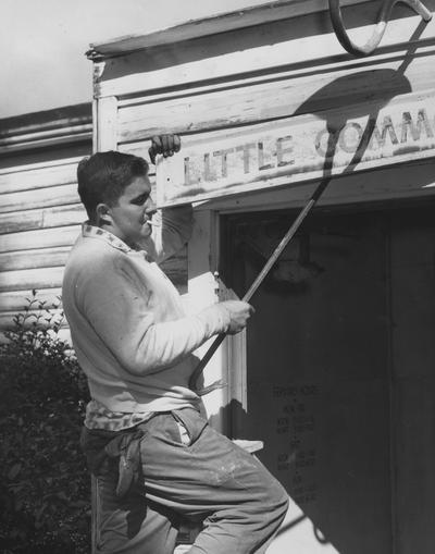 A man removing the sign to Little Commons. Received October 26, 1959 from Public Relations