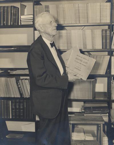 Ezra Gillis with the World War II Honor List of Dead and Missing, 1949. The list was placed in Memorial Coliseum. Photographer: Mack Hughes