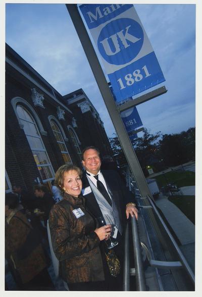 Marianne Smith Edge (Board of Trustees) and Stephen P. Branscum (Board of Trustees) are standing on the balcony of the Main Building during a ceremony for the reopening of the Main Building