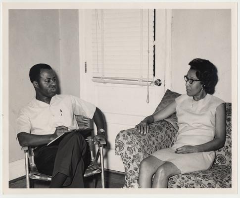 An African American Extension Agent is visiting in a home