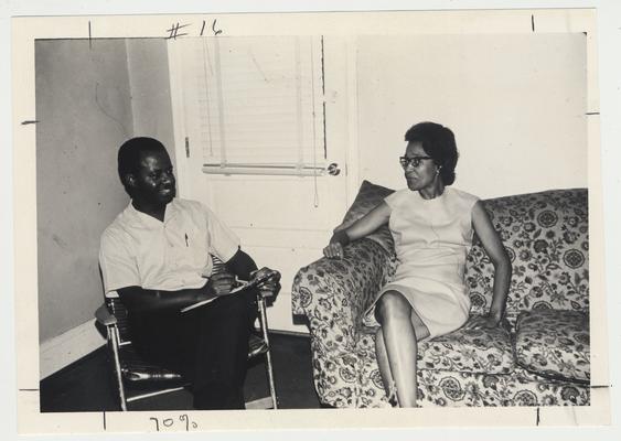 An African American Extension Agent is visiting in a home