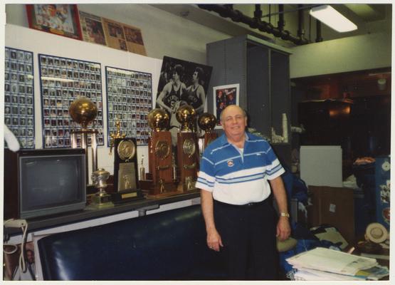 Bill Keightley, UK basketball equipment manager, is standing in front of trophies