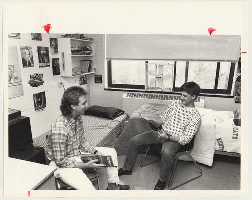 Two young men read magazines in a dorm room in Keeneland Hall