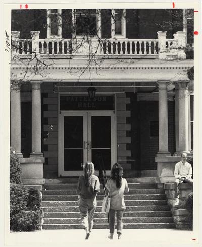 Two women are approaching the entrance to Patterson Hall