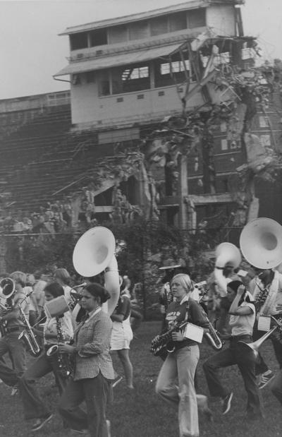 The destruction of the football field in September of 1974 is in the background while UK marching band plays. There is a duplicate print in Public Relations-Band File