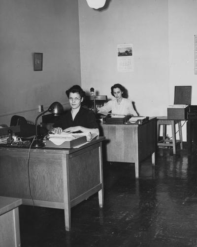 Helen Spickard (left) and Frances Brack (right) are seated at their desks in the Business Office. This photo appears first on page 16 in the 1941 