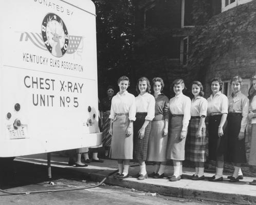 Registration--Group of female students beside an X-ray unit. From left to right: unidentified, Elaine Long, unidentified, Peggy Rollins, Joan Weggins, and Judy Semmons. Received September of 1957 from Public Relations