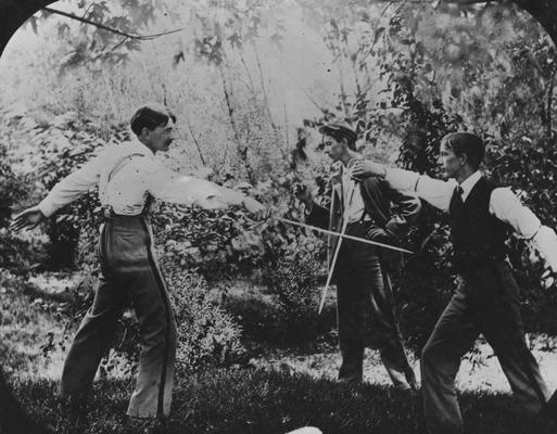 Two men fencing while another watches