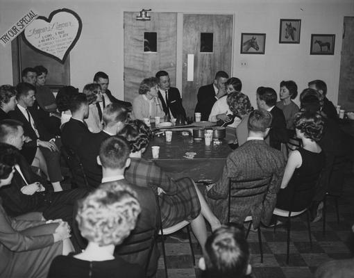 Lambda Chi Alpha mixer; Patty Pringle at end of table with elbow on table. Alice Akin with ukulele