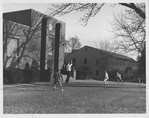 Left-Lafferty Hall; right-Social Science Building, demolished in 1949. Four men playing football in the yard. This photo appears first on page 215 in the 1963 Kentuckian